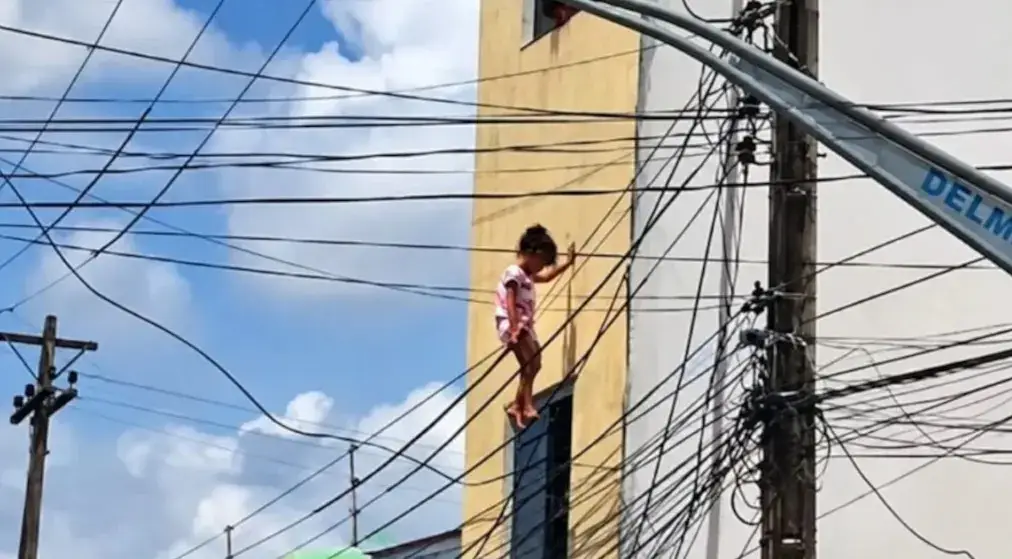 Menina cai do segundo andar e fica presa em fios elétricos; policial faz resgate arriscado